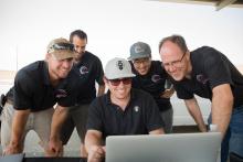 Photo of Chris Gerdes with researchers looking at code for MARTY