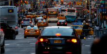 Photo of congested city street in New York City with taxi's, buses, person vehicles.