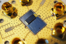 Angled-view photograph of the fully packaged device. The top (mechanical) chip is secured facedown to the bottom (qubit) chip by an adhesive polymer. (Image credit: Agnetta Cleland)