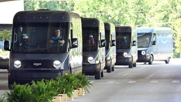 Photo of a line of Amazon Rivian delivery trucksw.