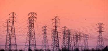Photo of power grids against an orange sky