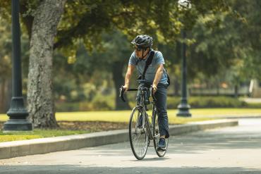 Cyclist bikes through Lomita Mall on Stanford campus