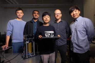 Research team shown holding prototype of the compact augmented reality glasses.