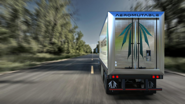 The back of a truck driving down a road.