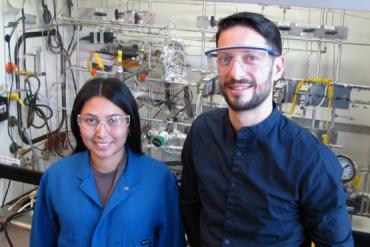 Photo of Aisulu Aitbekova, left, and Matteo Cargnello in front of the reactor where Aitbekova performed much of the experiments for this project. (Image credit: Mark Golden)