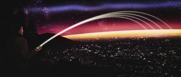 Image of a person holding a pocket-sized antenna with simulated beams emanating into the vast distance.