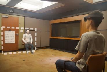 The photo shows an actor in place of a research participant and what they experienced during one of the studies. The area inside the dotted line is the field of view of the augmented reality goggles, which shows digital content such as avatar Chris.” (Image credit: Mark Miller and Stanford's Virtual Human Interaction Lab)