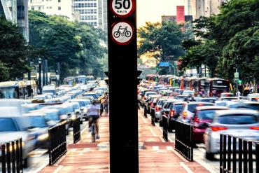 Photo of traffic congested urban street with center thoroughfare for bicycles and pedestrians