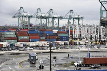 Photo of the Port of Los Angeles with truck carriers offloading and loading cargo from containers.