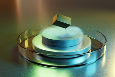 Metal disks in a shallow bowl with a cube levitating