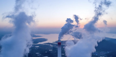 Aerial photo of a town with smokestacks billowing in the foreground