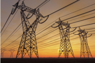 Picture of 3 large transformers against a sunset