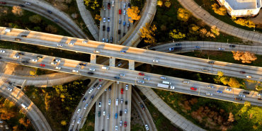 Aerial photo of a frewway with many on ramps and vehicles.