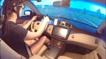 Photo of a human subject in a driving simulator with Near-infrared spectroscopy measuring brain activity