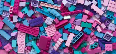 Colorful mix of different sized legos strewn on a table
