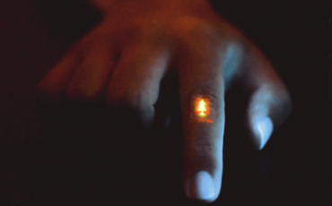 Zhitao Zhang wears the flexible light-emitting film, featuring a Stanford logo, on the knuckle of their finger. This shows how the film can hold up to flexing and wrinkling. (Image credit: Zhitao Zhang and Jiancheng Lai of Bao Group Research Lab)