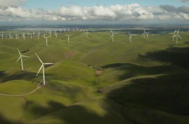 Overhead photo of grassy rolling hills with wind turbines