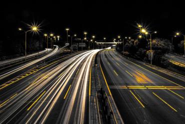 Graphic of a highway at night with streams of light on the road